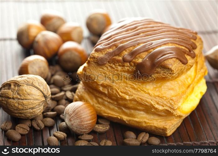 cake with chocolate, coffee beans and nuts lying on a bamboo mat
