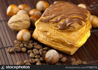 cake with chocolate, coffee beans and nuts lying on a bamboo mat