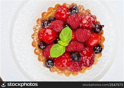 Cake with fresh berries and mint closeup