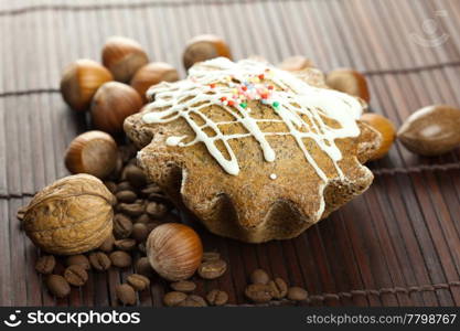 cake with icing, coffee beans and nuts lying on a bamboo mat