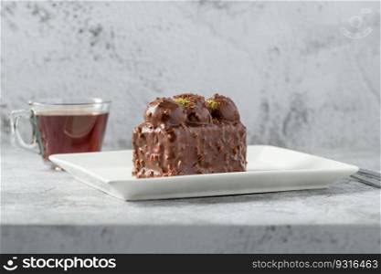 Cake with profiteroles with tea on stone table