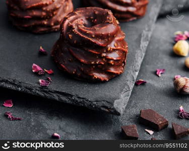 cakes in chocolate glaze on stone board