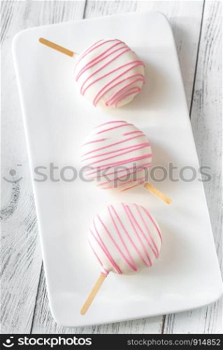 Cakes in the shape of popsicles on the white plate: top view