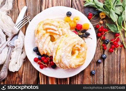 cakes with cream and berries on plate