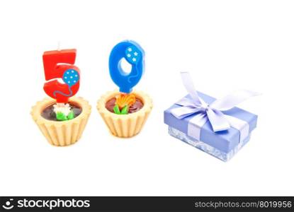 cakes with fifty years birthday candles and gift on white background