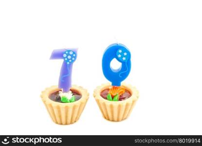 cakes with seventy years birthday candles on white