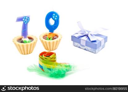 cakes with seventy years birthday candles, whistle and gift on white