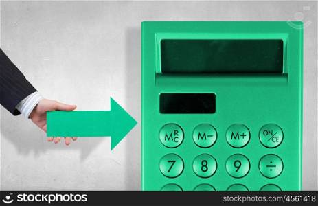 Calculations and accounting . Businessman hand with arrow pointing at calculator