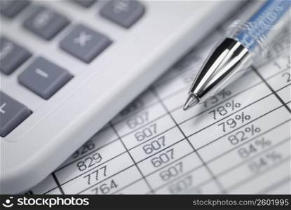 Calculator and a ballpoint pen on financial data