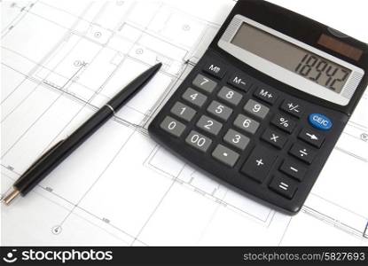 Calculator and pen on a blueprint. Engineering equipment.