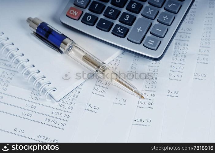 Calculator and pen on sheets of banking report