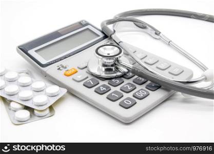 Calculator and stethoscopes on white background