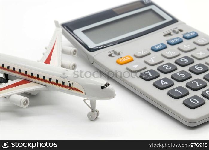 Calculator and toy plane on white background