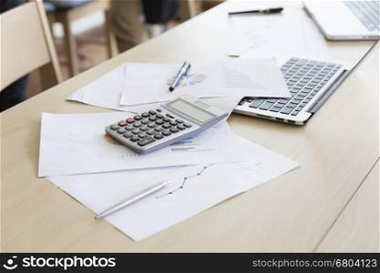 calculator, business document and laptop computer notebook on wooden table