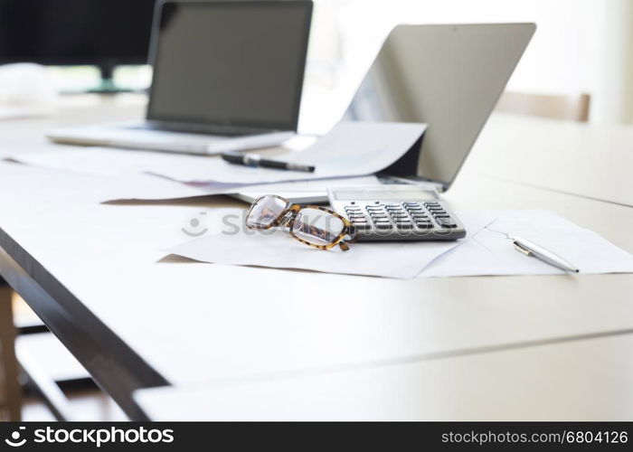 calculator, business document and laptop computer notebook on wooden table