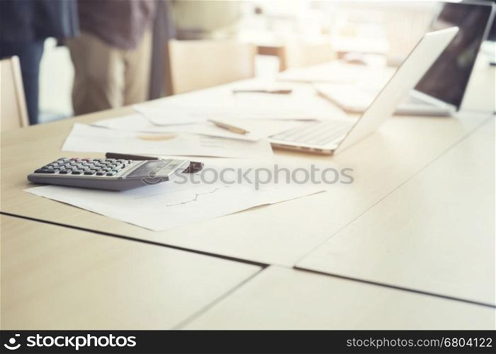 calculator, business document and laptop computer notebook on wooden table, vintage tone