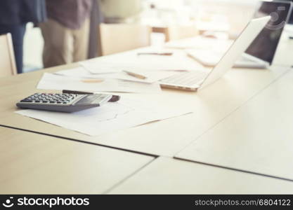 calculator, business document and laptop computer notebook on wooden table, vintage tone