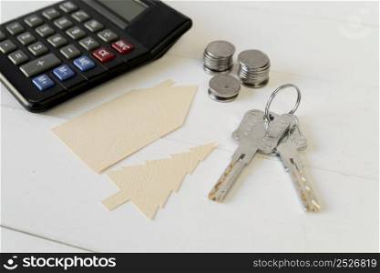 calculator coins stack keys with house tree paper cutout white wooden table