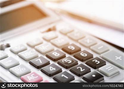 calculator focus at on press button keyboard. calculator color gray and documents pen on table. concept calculate account finance.