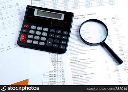 calculator, magnifier on financial reports. Business concept. Calculator and magnifying glass on financial documents