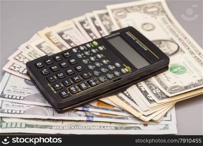 calculator on dollars isolated on gray background