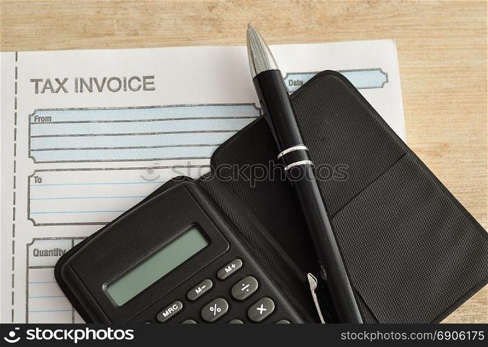 Calculator, pen and invoice book