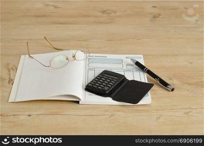 Calculator, pen, glasses and invoice book