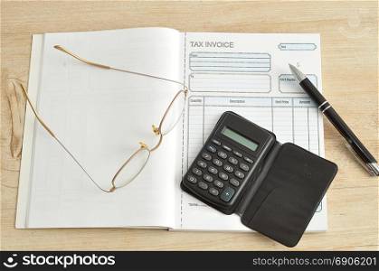 Calculator, pen, glasses and invoice book