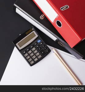 calculator pencils paper paper files black background