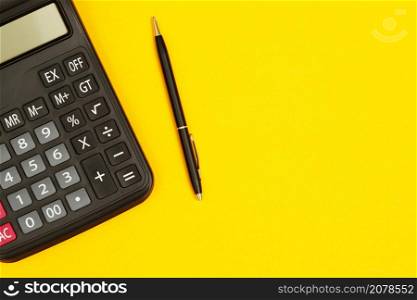 calculator with pen for accountant on yellow background
