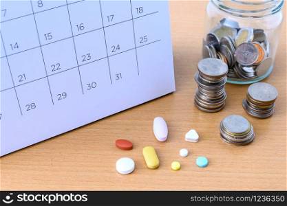 Calendar and drugs and coins on table. concept Healthcare