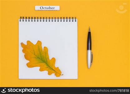Calendar month October, blank open notepad with pen and autumn leaves on yellow background. Mockup Top view Flat lay Template for your design, invitation, postcard.. Calendar month October, blank open notepad with pen and autumn leaves on yellow background. Mockup Top view Flat lay Template for your design, invitation, postcard