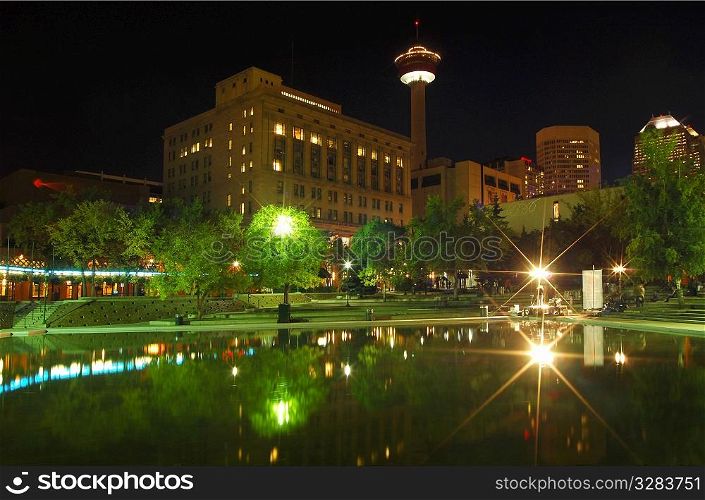 Calgary Tower reflecting in water at night.