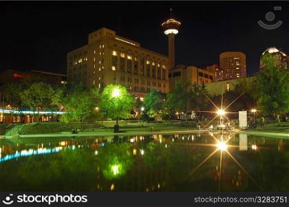 Calgary Tower reflecting in water at night.