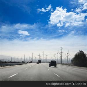 California road with electric windmills aerogenerators and traffic