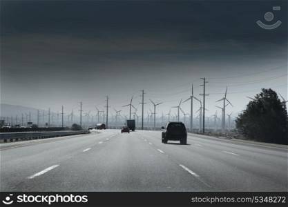 California road with electric windmills aerogenerators and traffic
