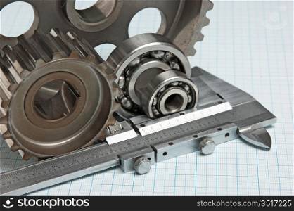 caliper with gears and bearings on graph paper