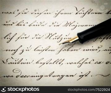 Calligraphic handwritten text and vintage ink pen. Retro style toned picture