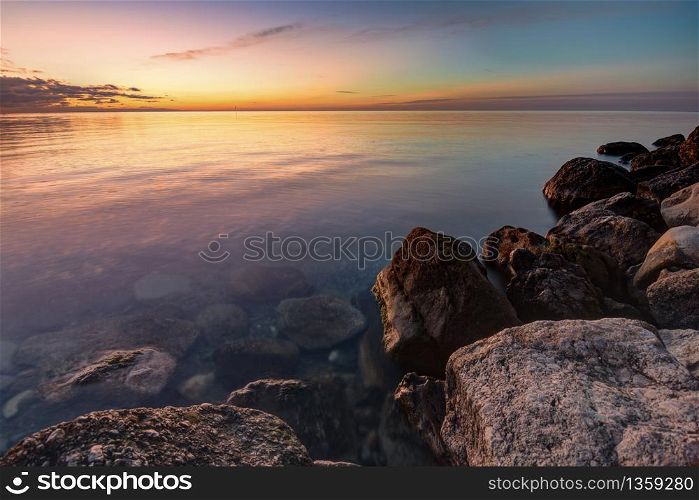 Calm beautiful evening seascape, in the foreground huge stones