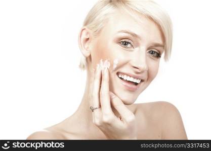 calm beauty portrait of a smiling young woman putting cream