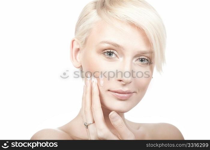 calm beauty portrait of a young woman putting cream