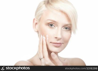 calm beauty portrait of a young woman putting cream