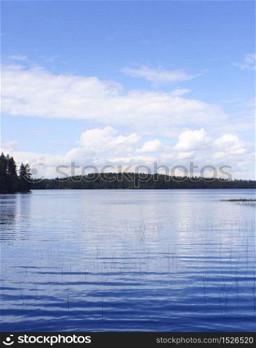 Calm blue lake with blue sky white clouds reflection background