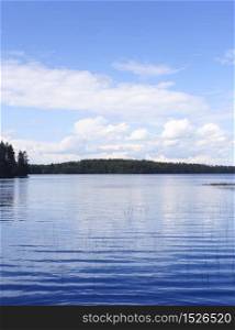 Calm blue lake with blue sky white clouds reflection background