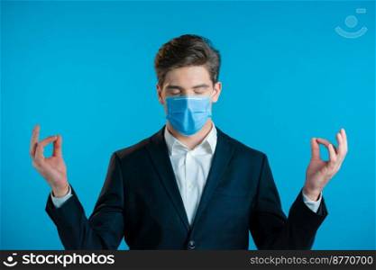 Calm businessman in c&aign suit relaxing, meditating. Handsome european man calms down, breathes deeply with mudra om. Calm businessman in c&aign suit and mask relaxing, meditating. Handsome european man calms down, breathes deeply with mudra om.