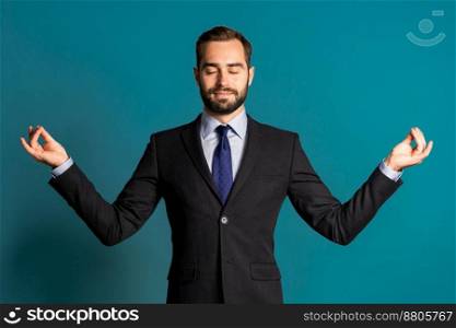 Calm businessman in campaign suit relaxing, meditating. Handsome european man calms down, breathes deeply with mudra om.. Calm businessman in suit relaxing, meditating. Handsome european man calms down