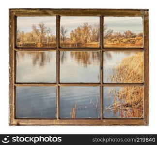 calm lake at sunset in northern Colorado, fall scenery as seen through a vintage cabin window