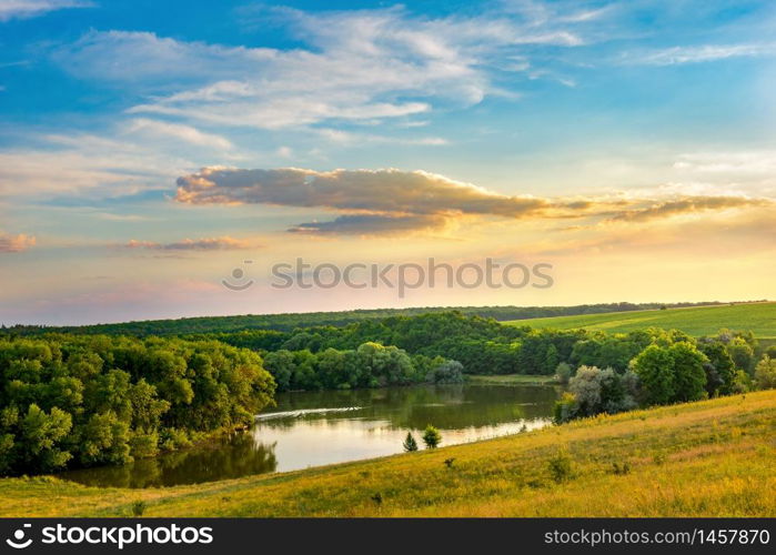 Calm lake in forest among hills at sunset. Lake in hills