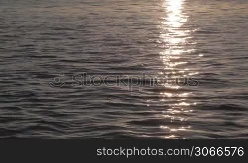 Calm water with sun reflection at dawn.