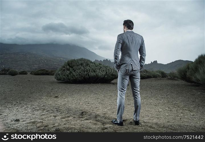 Calm, young businessman on a desert